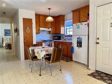 Kitchen with high end stove, tasteful backsplash, white fridge, decorative light fixtures, and light tile floors