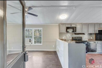 Kitchen with black microwave, a ceiling fan, gray cabinetry, dishwasher, and cooling unit