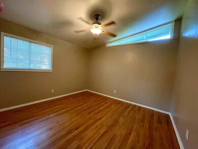 Empty room with wood finished floors, a ceiling f