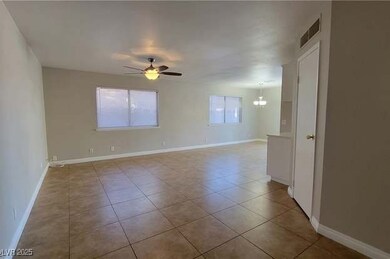 Tiled spare room featuring a ceiling fan, visible