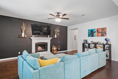 Living room with ceiling fan and dark wood-type flooring