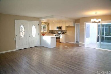 Great room with new laminate floor looking toward 