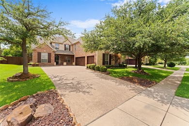 View of front facade with driveway, brick siding, and an attached garage
