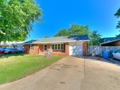 Ranch-style home featuring a garage, concrete driveway, and brick siding