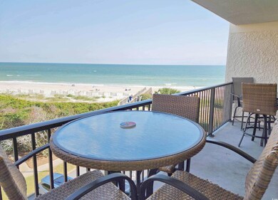 Balcony featuring a view of the beach and a water 