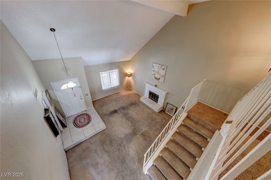 Entryway with stairs, beam ceiling, carpet floorin