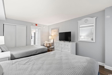Bedroom featuring dark wood-type flooring, baseboa