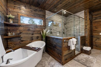 Full bathroom featuring wood walls, a freestanding bath, wood ceiling, and a shower stall