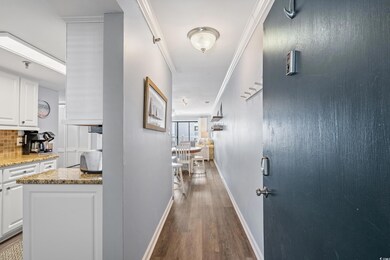 Hallway featuring baseboards, crown molding, and w