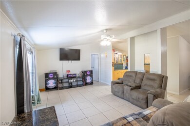Living room with lofted ceiling, ceiling fan, and