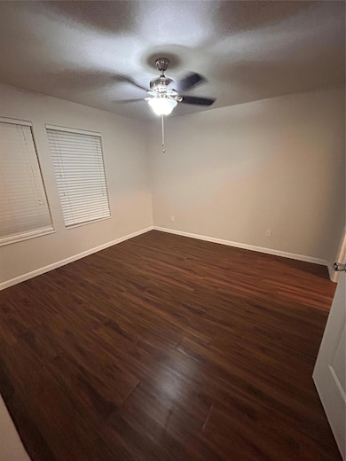Unfurnished room featuring ceiling fan and dark w