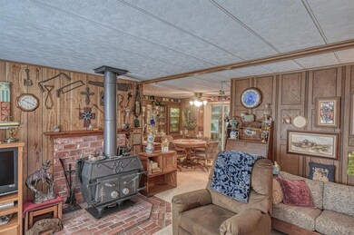 Living room featuring wood walls, ceiling fan, and