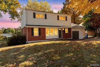 View of front facade with an attached garage, brick siding, and a lawn
