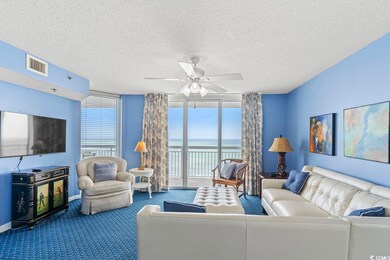 Living room featuring a water view, a textured cei