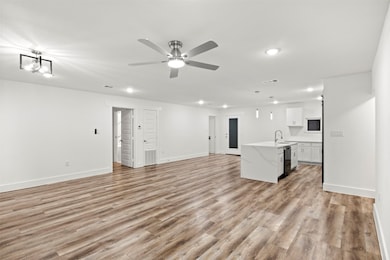 Unfurnished living room featuring light wood-type flooring, a ceiling fan, and recessed lighting