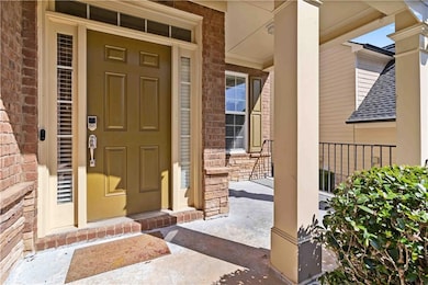 Doorway to property featuring a porch, brick sidin