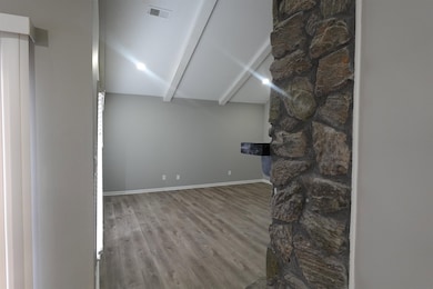 Unfurnished living room with vaulted ceiling, wood