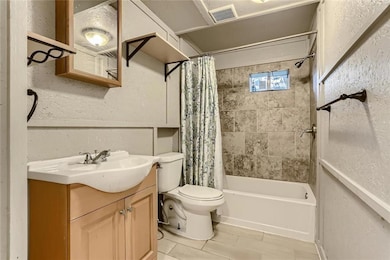 Bathroom with toilet, shower / bath combo, vanity
