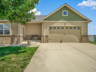 View of front facade featuring brick siding, board and batten siding, an attached garage, and concrete driveway