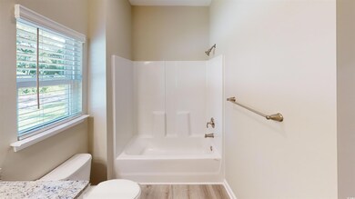 Full bathroom with bathtub / shower combination, vanity, and light wood-style floors
