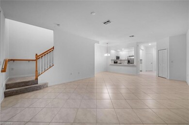 Unfurnished living room with stairway, light tile 