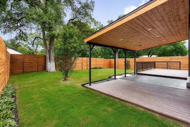 Fenced backyard featuring a deck