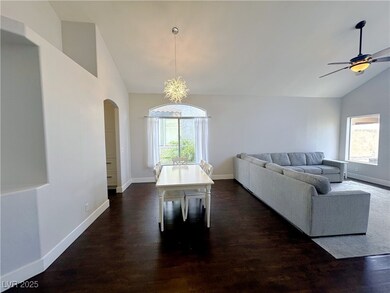 Living room with arched walkways, baseboards, dark