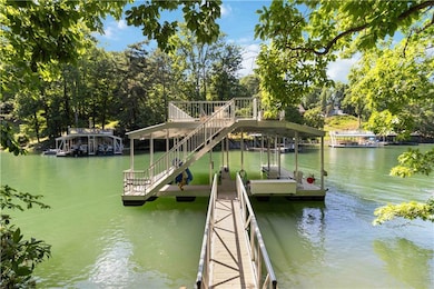 Dock area with a water view and view of scattered trees
