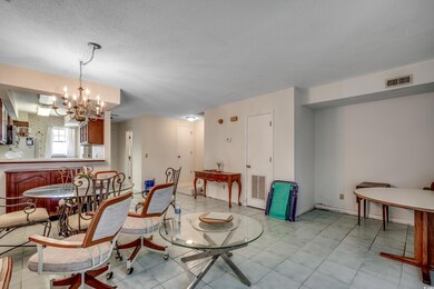 Dining room featuring a chandelier, light tile patterned floors, and a textured ceiling