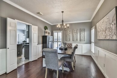 Dining room located next to kitchen with crown moulding, stylish chandelier, Plantation shutters, hand scrapped wood floors and the perfect paint for any decor.