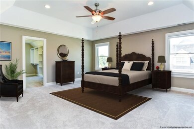 This lush master suite features a tray ceiling lig