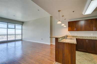 Kitchen featuring a sink, a peninsula, baseboards,