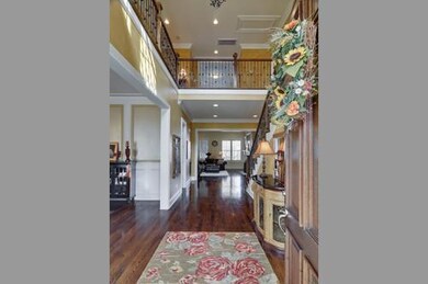 The grand entrance displaying the fanatic millwork of crown molding throughout, richly stained newell post and decorative rod iron spindles.