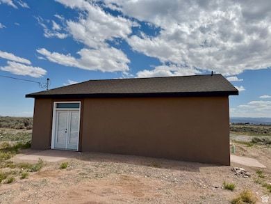 View of home's exterior featuring stucco siding and roof with shingles