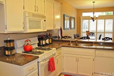 Light and open kitchen has granite counters, a bre