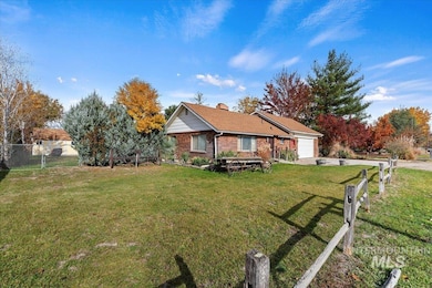 View of front of house featuring brick siding, a garage, a chimney, and driveway