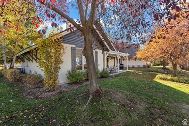 View of property exterior featuring a lawn, a patio area, and stucco siding
