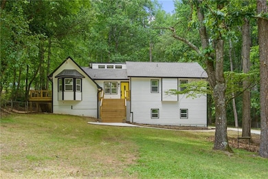 Back of house featuring a yard and roof with shingles
