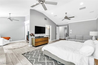 Bedroom with vaulted ceiling, light wood-style flo