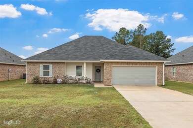 View of front of house featuring a front yard, concrete driveway, and a garage
