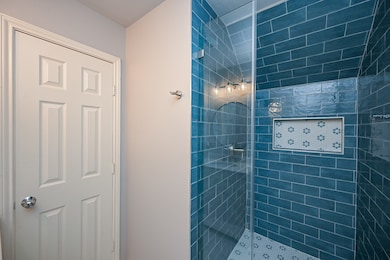 This bathroom features a sleek glass-enclosed show