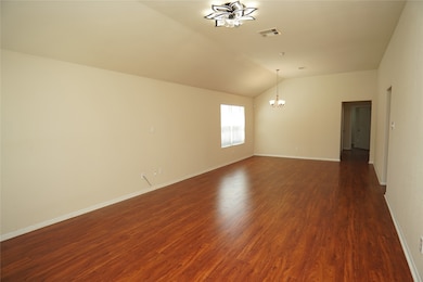 This spacious room features warm wood flooring, ne