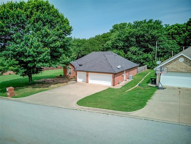 Ranch-style house with a front lawn, concrete driveway, brick siding, and roof with shingles