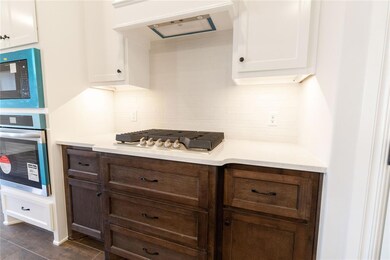 Kitchen featuring black microwave, ventilation hoo