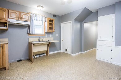 Kitchen with light flooring, glass insert cabinets, under cabinet range hood, and light countertops