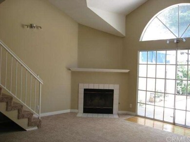 high ceiling living area with fireplace, and door 