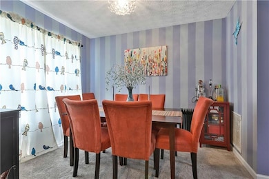 Carpeted dining area with a textured ceiling