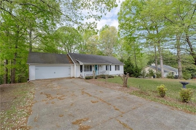 Single story home with a front yard, a garage, cov