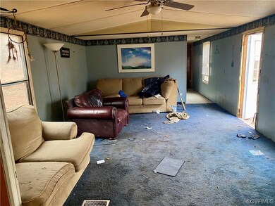 Carpeted living room featuring vaulted ceiling and