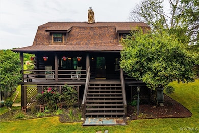 Rear view of house featuring stairway, roof with s